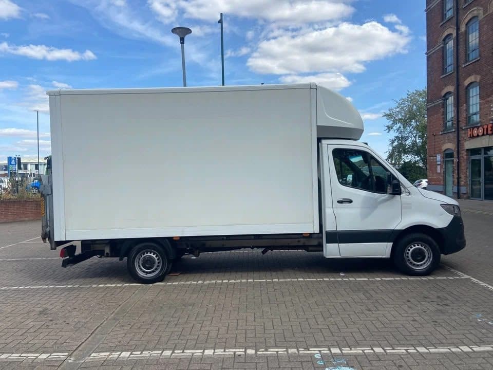 Side profile view of the white 3.5-tonne Luton box van parked on commercial paving