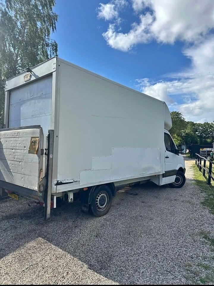 Rear perspective displaying the rear roller shutter door and heavy-duty hydraulic tail lift mechanism
